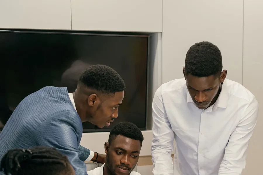 Colleagues leaning over a laptop to give feedback on the work